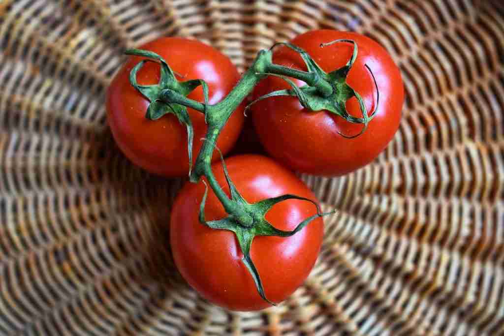 three tomatoes on a wicker mat viewed overhead