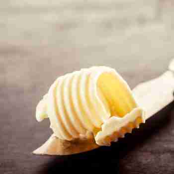 a close up of a butter knife with a knob of butter