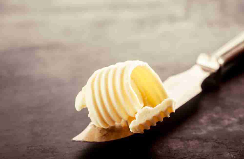 a close up of a butter knife with a knob of butter