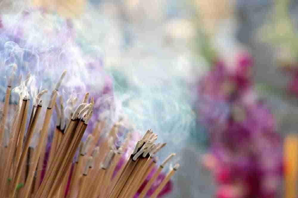 a close up of multiple burning incense sticks