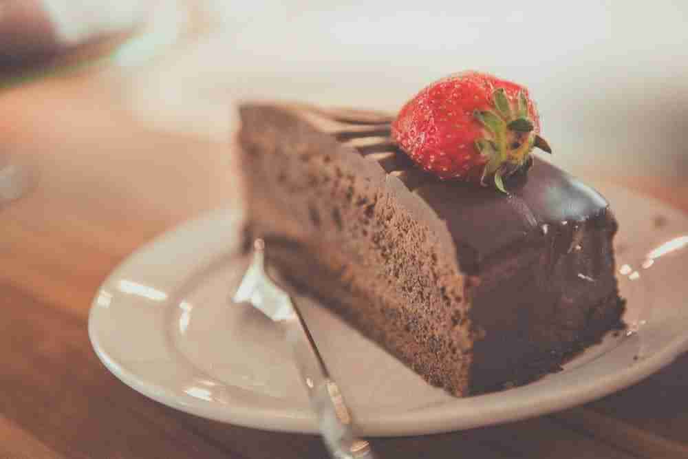 close up of a slice of chocolate cake with a strawberry on top
