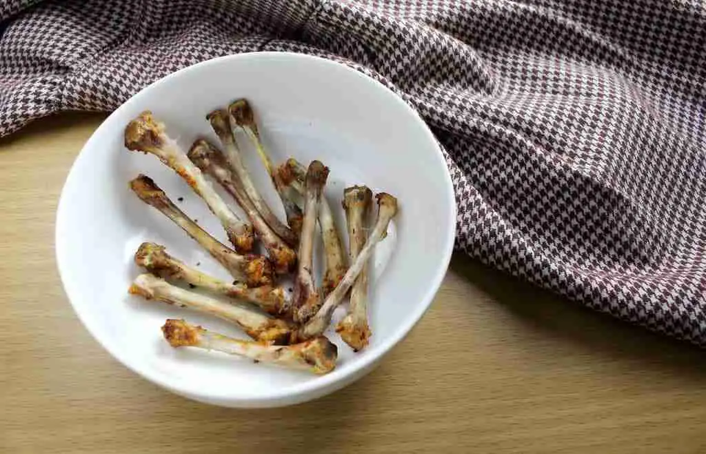 a bowl of cooked chicken leg bones